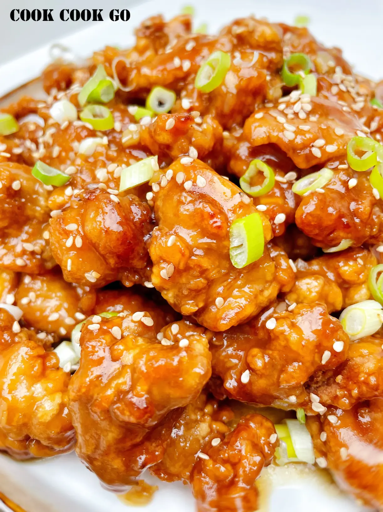 Chinese crispy honey chicken with green onions on top