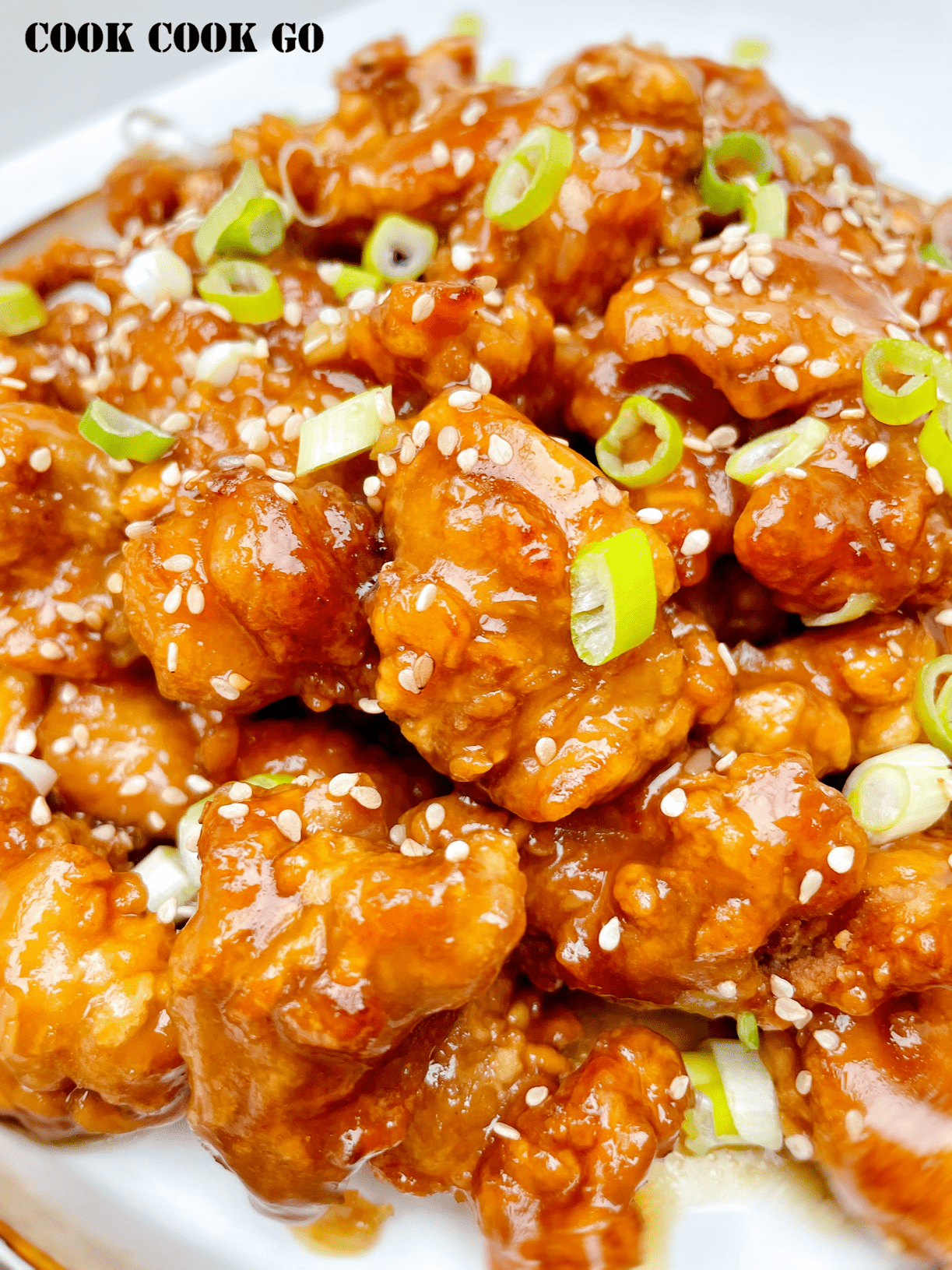 Chinese crispy honey chicken with green onions on top